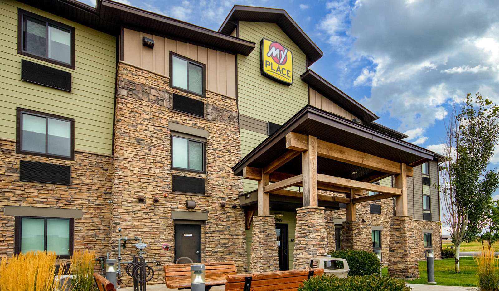 Exterior of My Place Hotel-Bozeman, MT from ground level looking up at front entrance and logo sign.