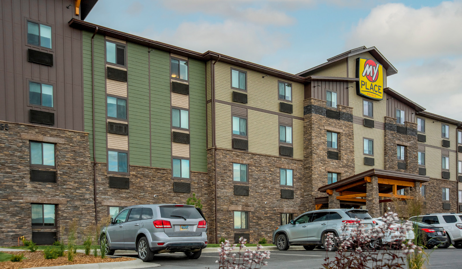 Exterior of My Place Hotel-Kalispell, MT under a partly cloudy sky.