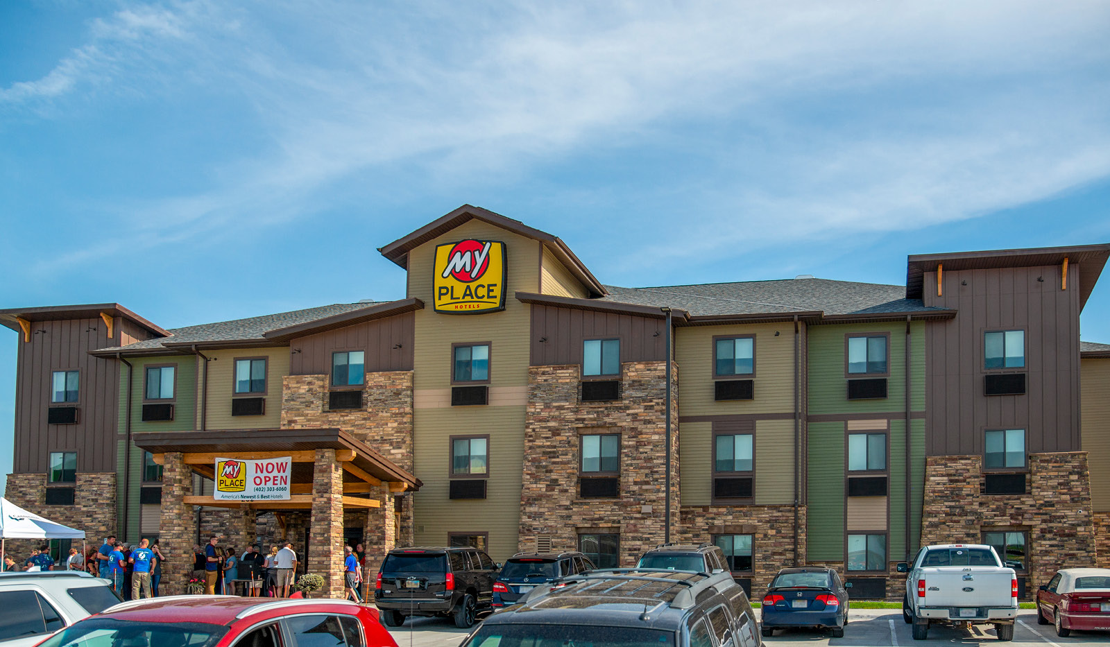 Exterior of My Place Hotel-Hastings, NE with a parking lot full of vehicles.