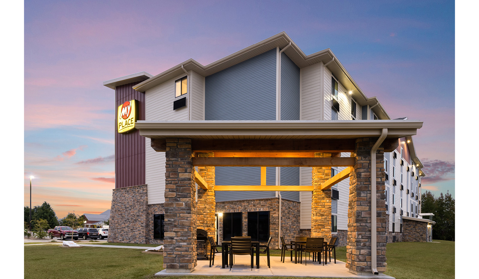 Side view of the hotel featuring the covered grilling pavilion with multiple grills, chairs and a table.