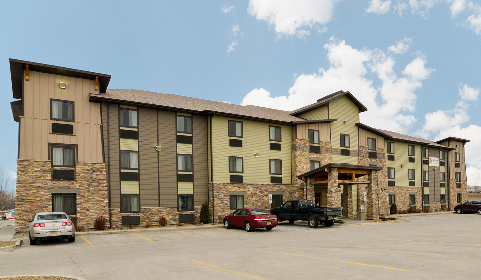 Exterior of My Place Hotel-Bismarck, ND under a partly cloudy sky.