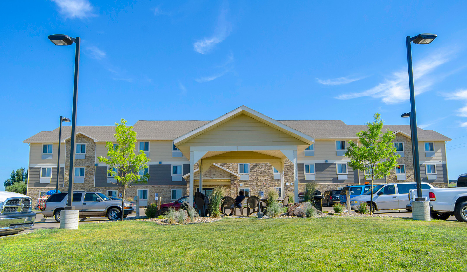 Exterior of My Place Hotel-Dickinson, ND featuring landscaped grass outside hotel's main door.