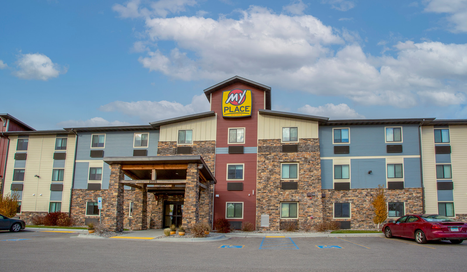 Exterior of My Place Hotel-Fargo, ND under blue cloudy sky.