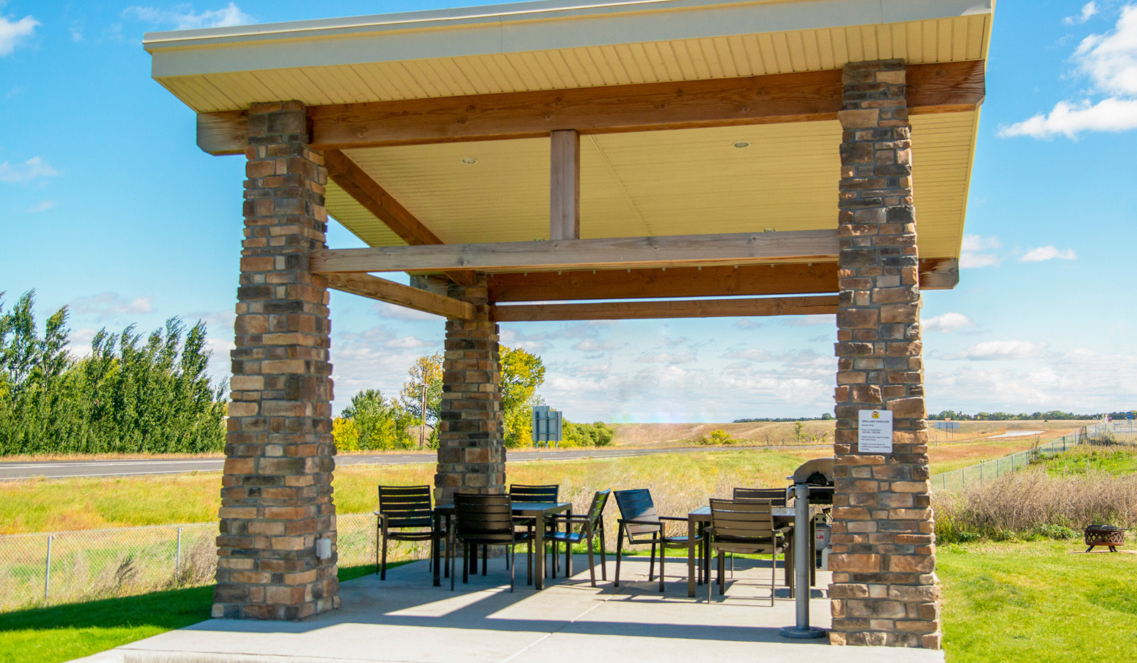 Exterior of My Place Hotel-Jamestown, ND's gilling pavilion with a prairie backdrop.