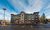 Wide view of exterior of My Place Hotel-Bend, OR with parking lot and surrounding trees.