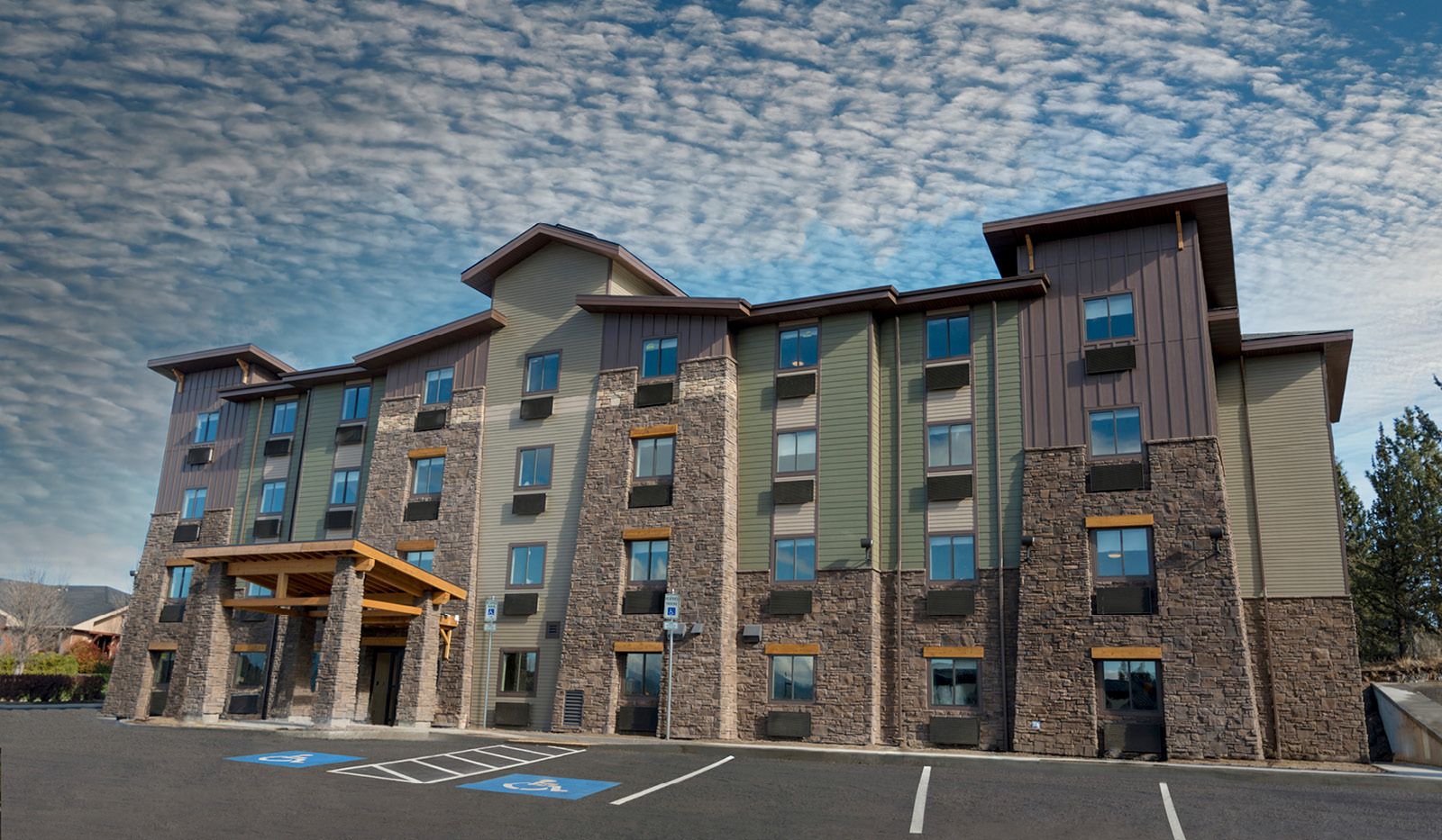 Exterior of My Place Hotel-Bend, OR under a partly cloudy sky.