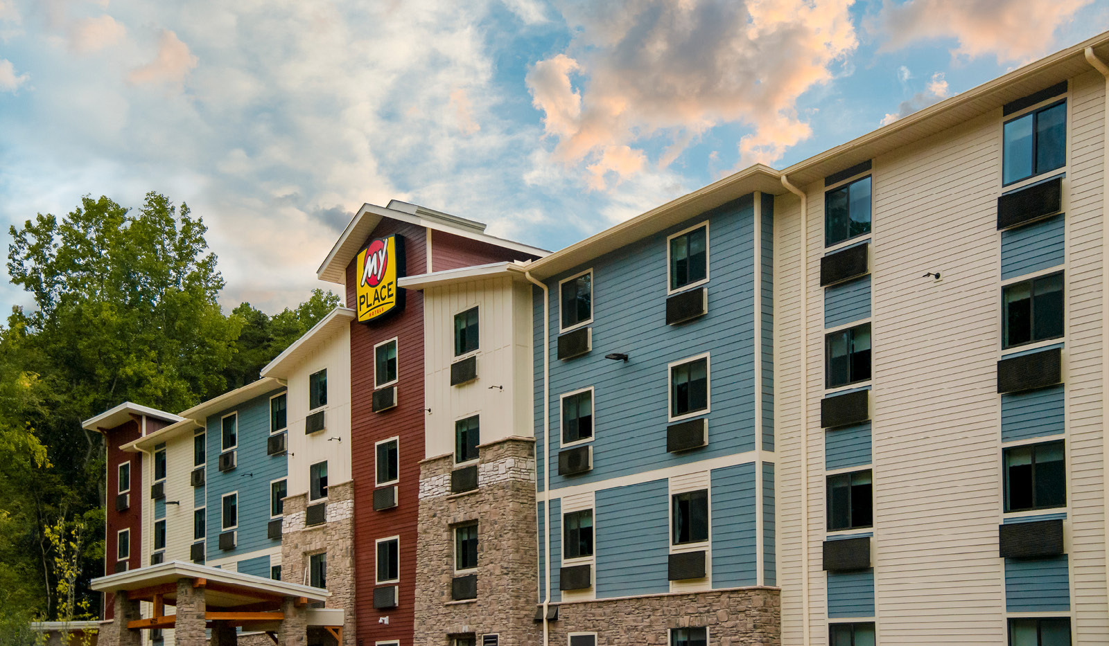 Exterior of My Place Hotel-Medford, OR under a partly cloudy blue sky.