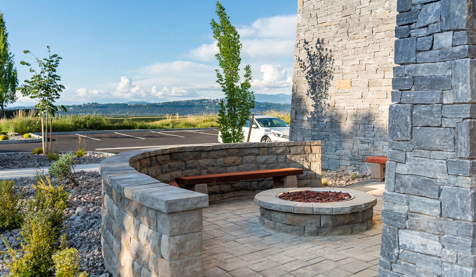 Exterior of My Place Hotel-Portland East, OR's stone fireplace pit and benches.