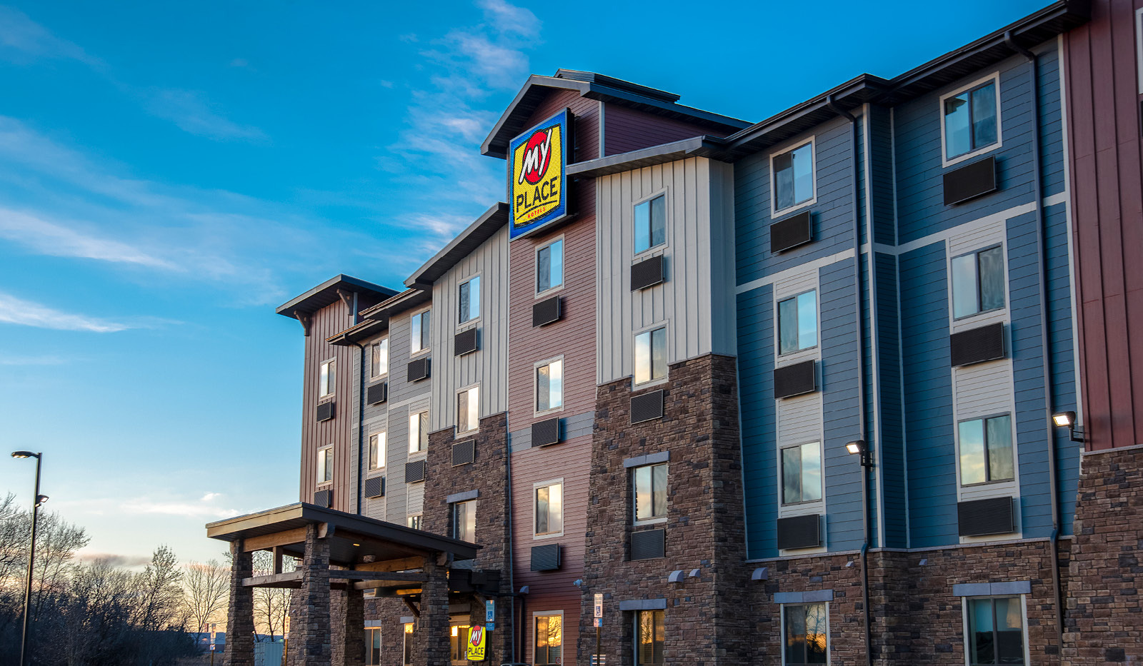 Exterior of My Place Hotel-Brookings, SD under a blue sky.