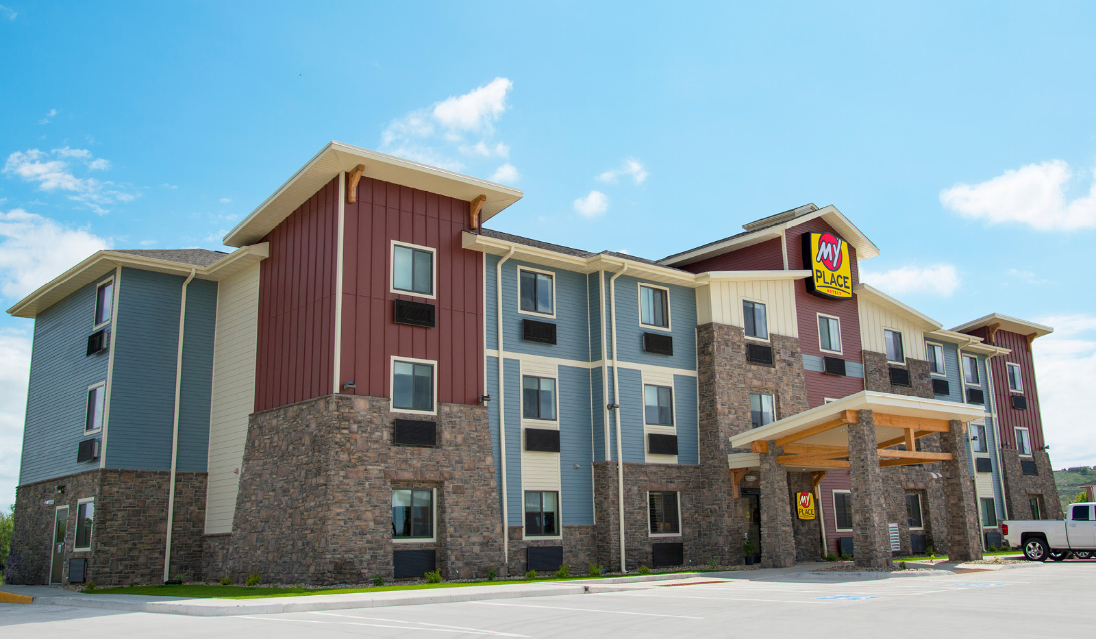 Exterior of My Place Hotel-Ft. Pierre, SD under blue sky.