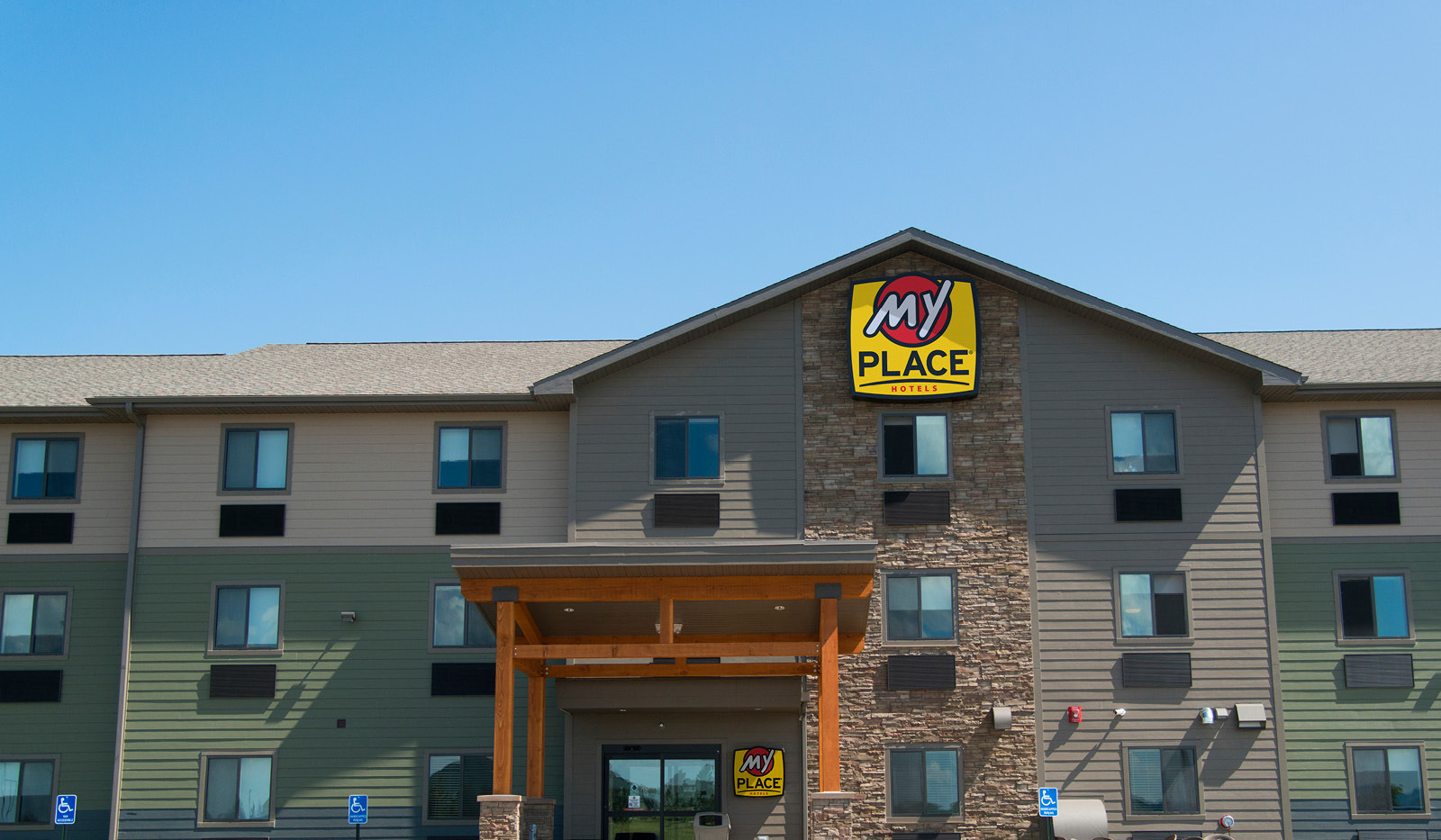 Top-half of exterior of My Place Hotel-Rapid City, SD under a blue sky.