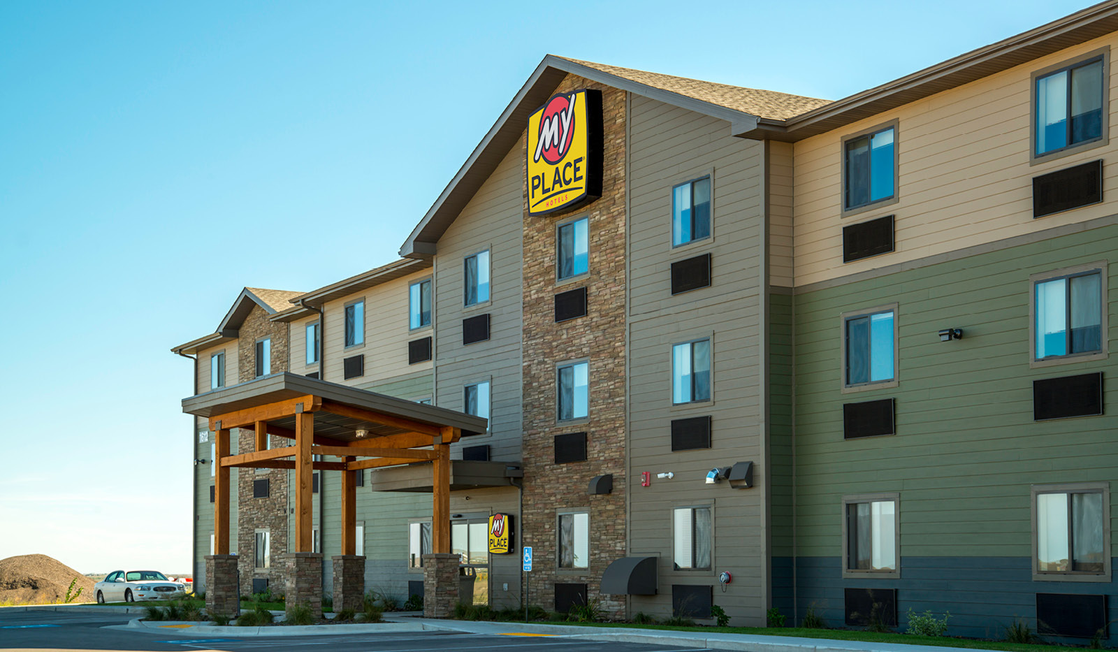 Exterior of My Place Hotel-Rapid City, SD under a blue sky.
