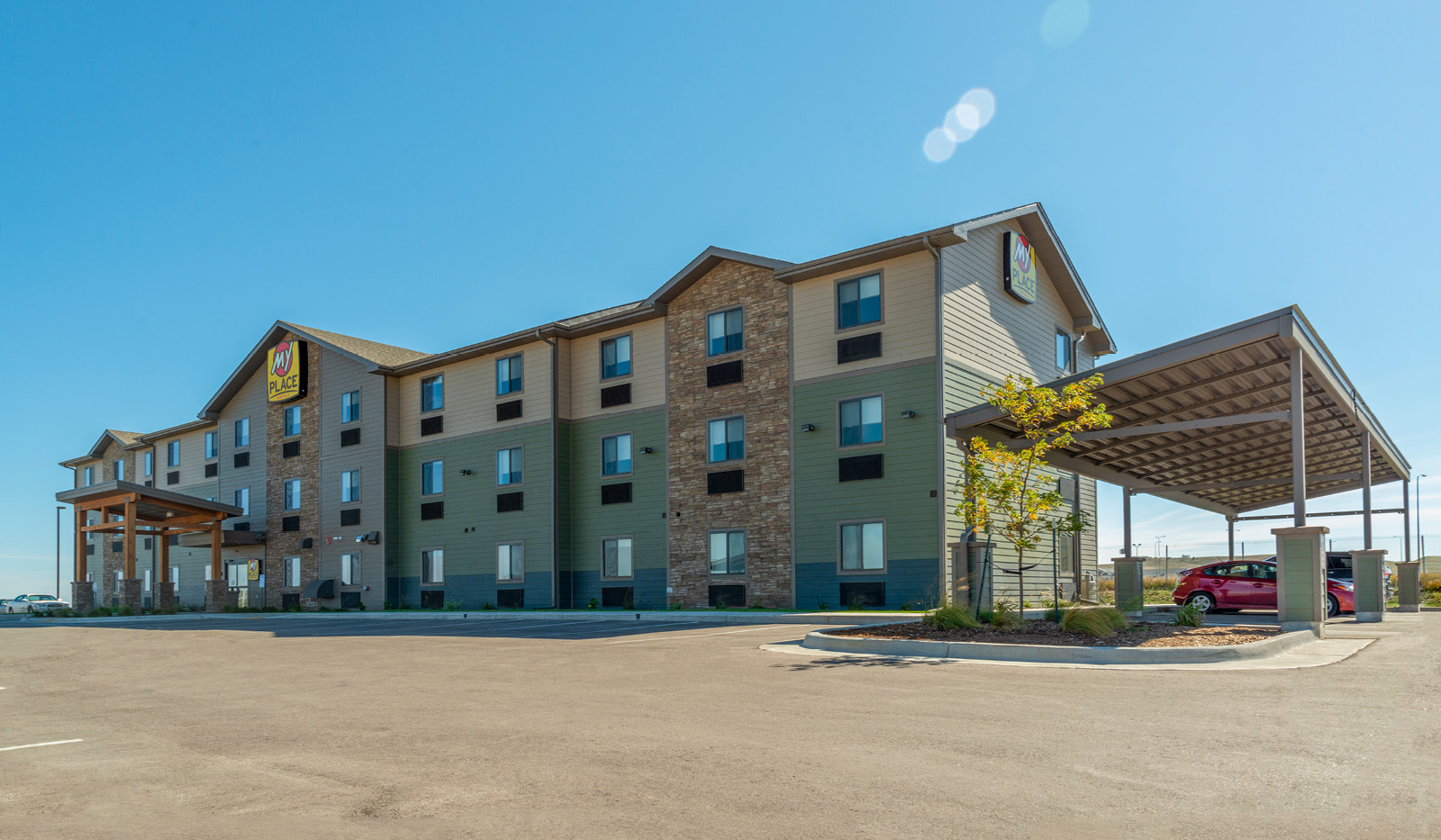 Wide exterior of My Place Hotel-Rapid City, SD with grilling pavilion.