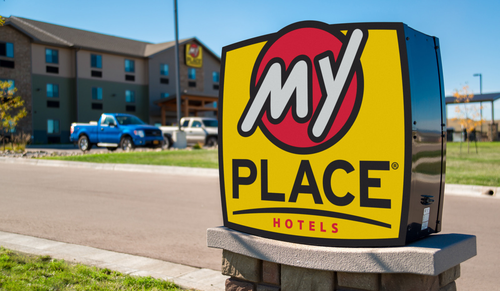 My Place Hotel-Rapid City, SD parking lot sign with hotel exterior in the background.