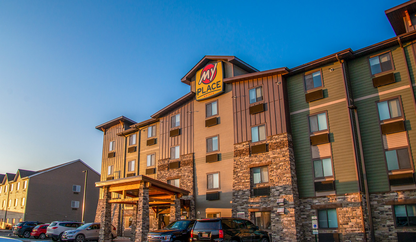 Exterior of My Place Hotel-Watertown under a clear blue sky.