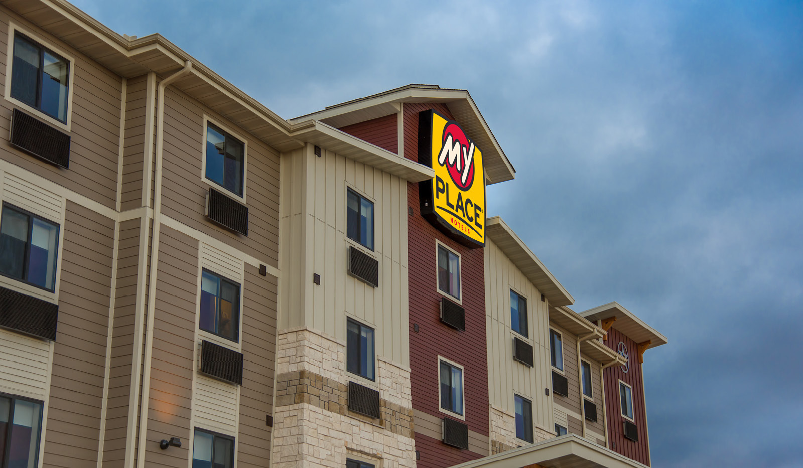 Exterior of My Place Hotel-Lubbock, TX under a cloudy sky at dusk.