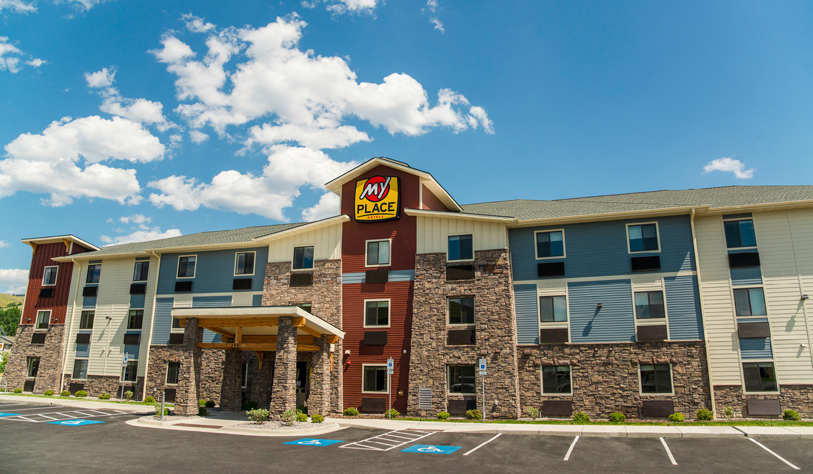 Exterior of My Place Hotel-Midland, TX under a partly cloudy blue sky.