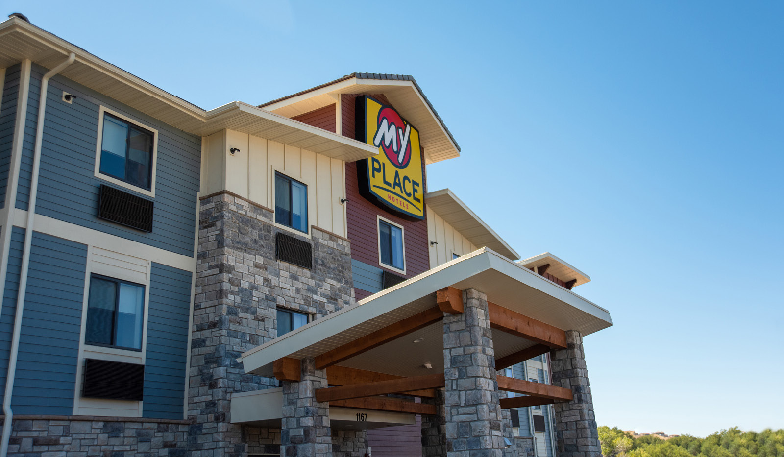Angled exterior of My Place Hotel-Hurricane, UT under a clear blue sky.