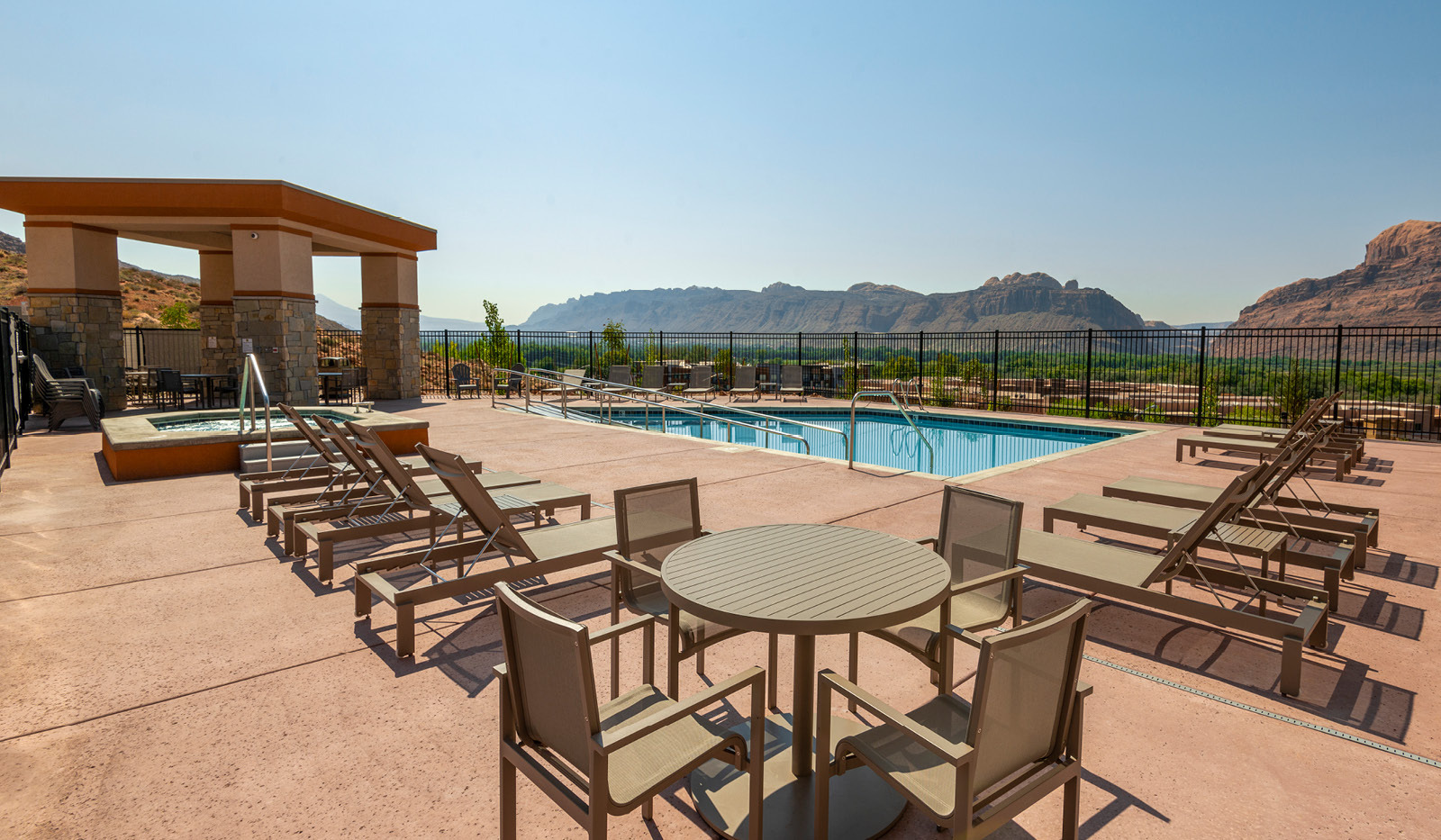 Exterior My Place Hotel-Moab, UT's pool, tables, and chairs.