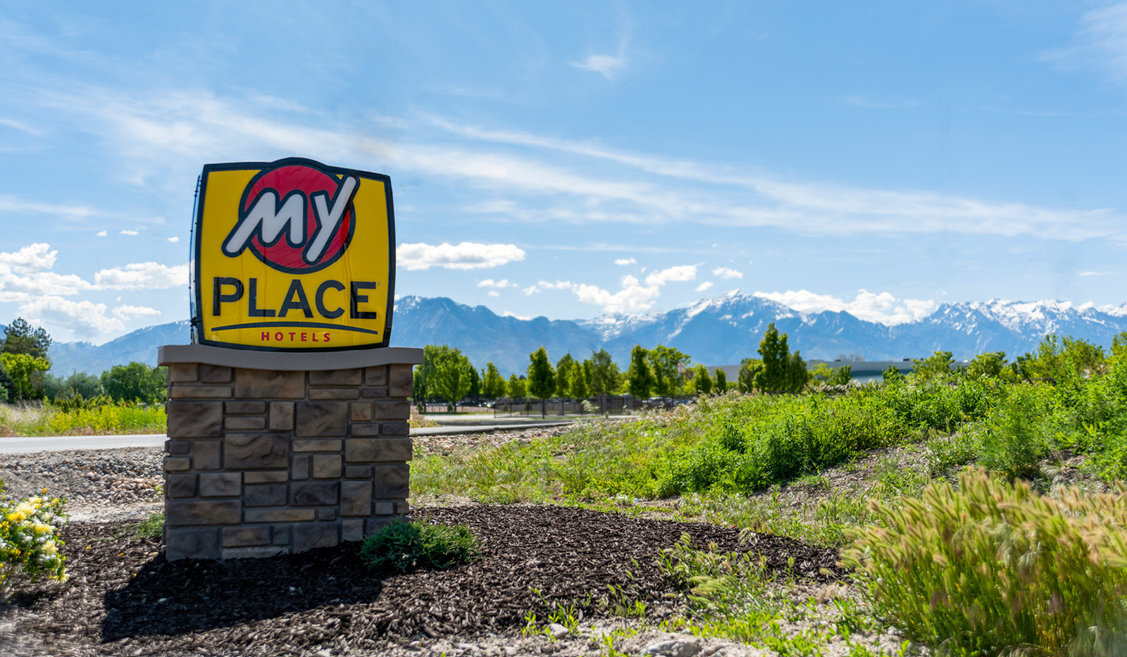 Exterior My Place Hotel-West Valley City, UT's logo sign with mountain range in the distance.
