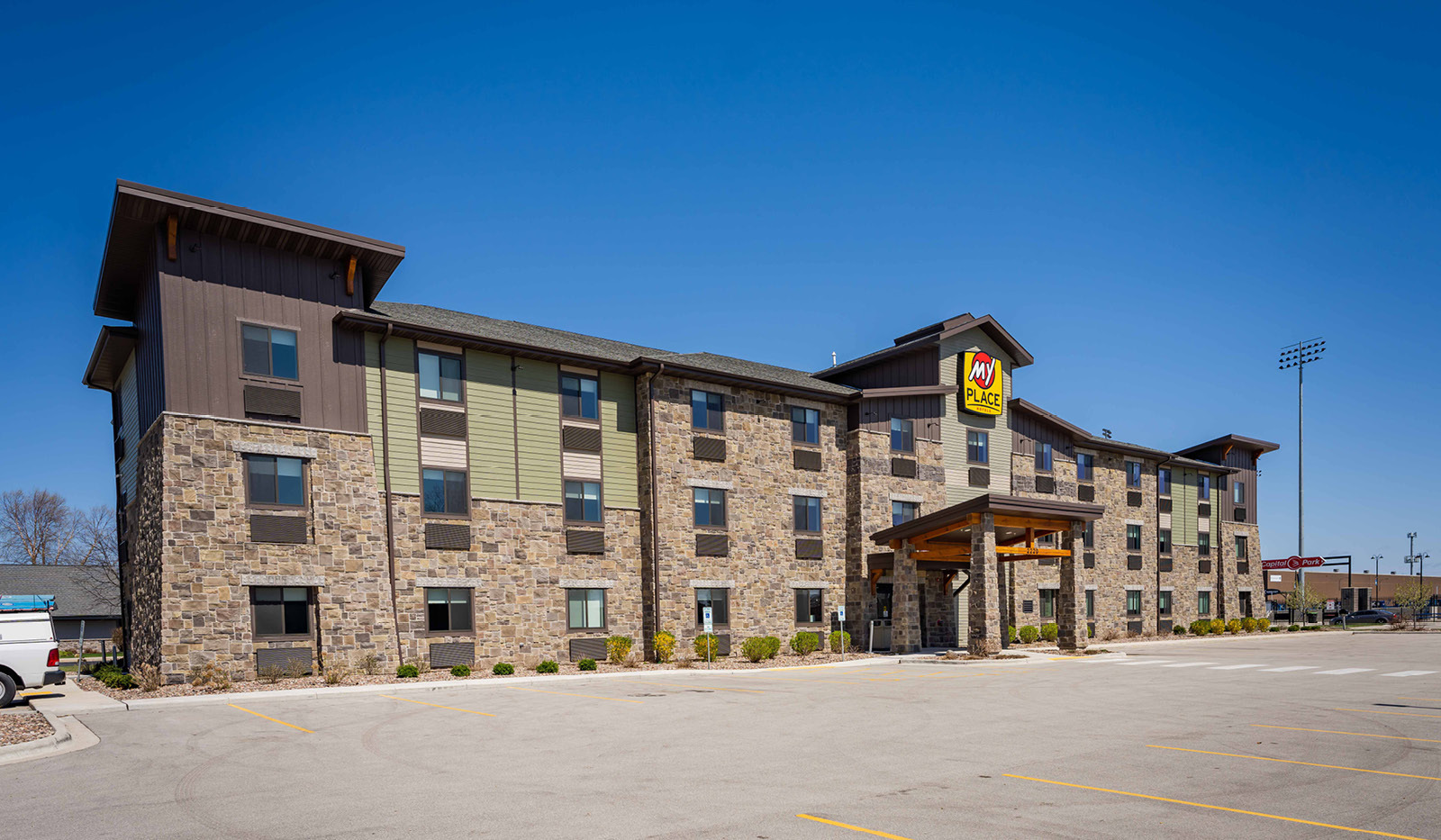 Wide exterior My Place Hotel-Green Bay, WI and parking lot.