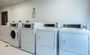 Interior laundry facility with six washer and dryer units.