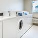 White washer and dryers inside the laundry facility at My Place Hotel