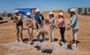 People in hard hats breaking ground.
