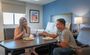 Man and woman enjoying food over a table inside a My Place room.