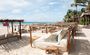 Outdoor beds with canopies on the beach with an ocean view.