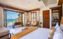 Bedroom with a coastal vibe and an open patio overlooking the ocean view.