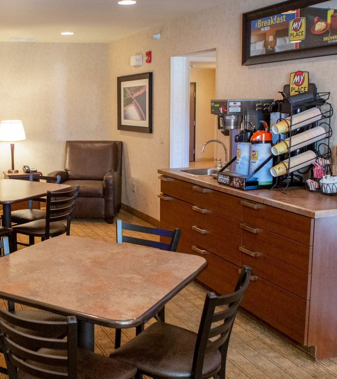 Tables and chairs next to the My Coffee station in the lobby at My Place Hotels.