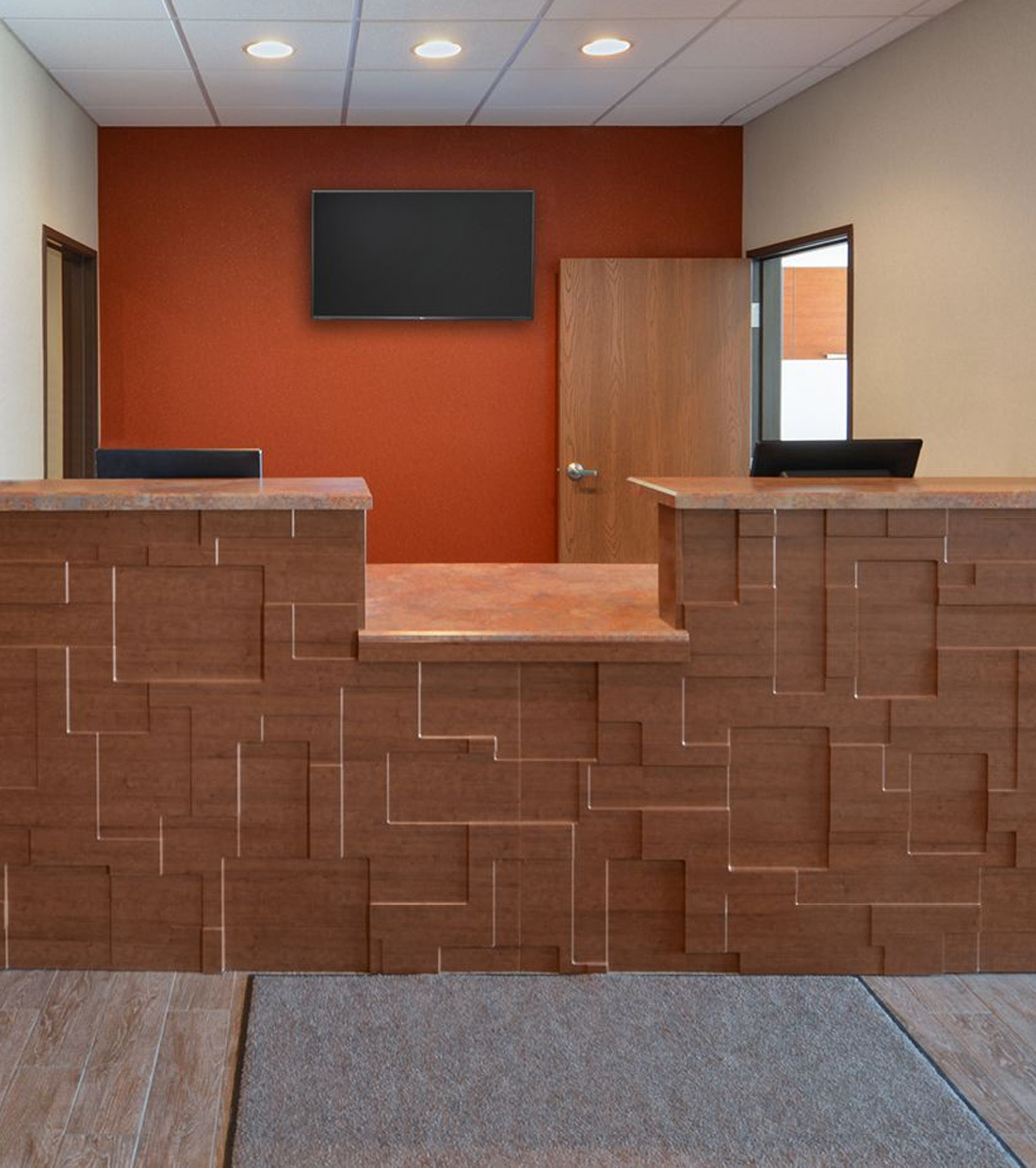 Brown front desk area inside My Place Hotel lobby.
