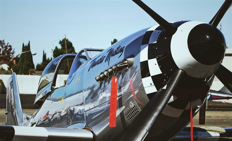 An older airplane sets below a clear blue sky.