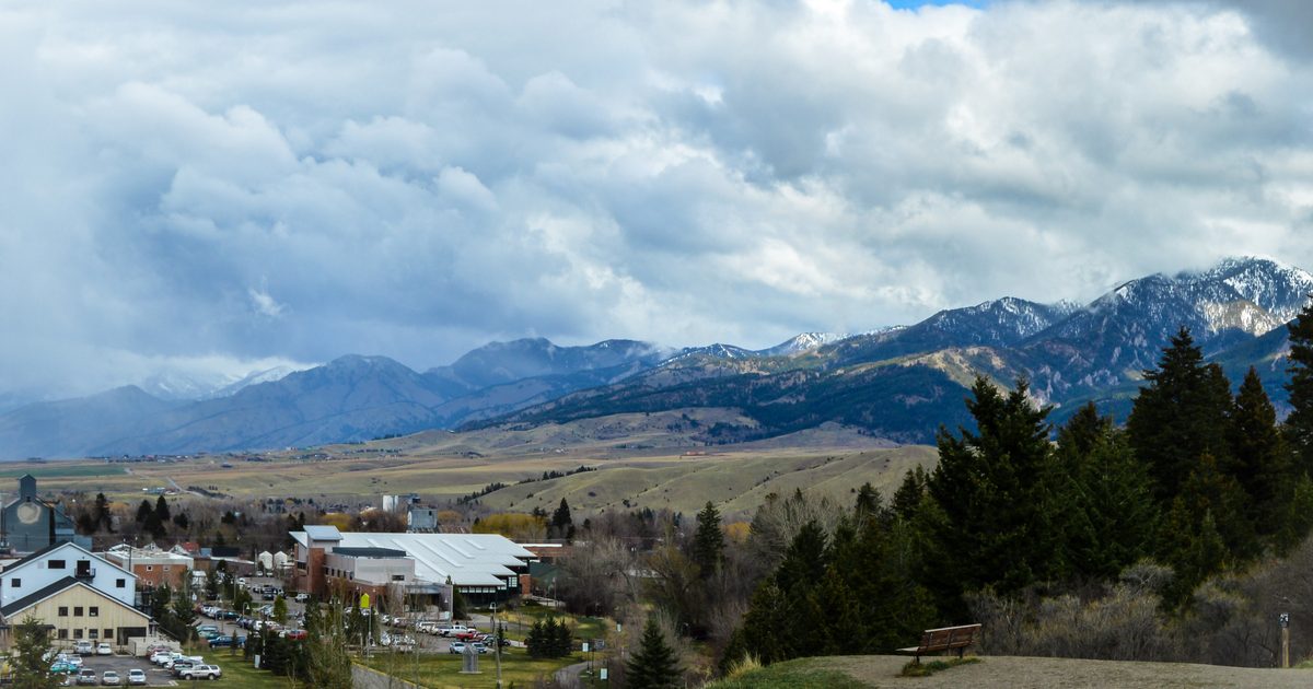 View of mountains overlooking a small group of houses in Bozeman, MT.