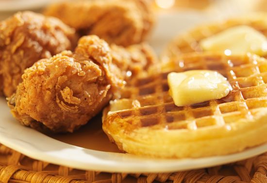 Breaded chicken and waffles on a white plate.