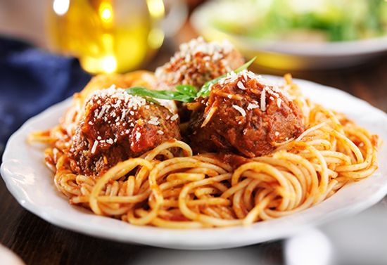 Plated spaghetti with three large meatballs.