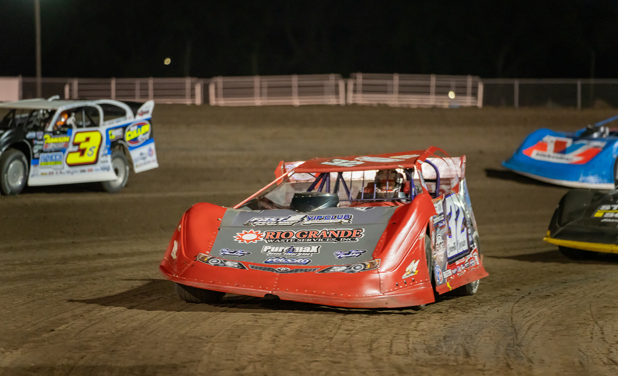 4 racecars speeding around the bend.