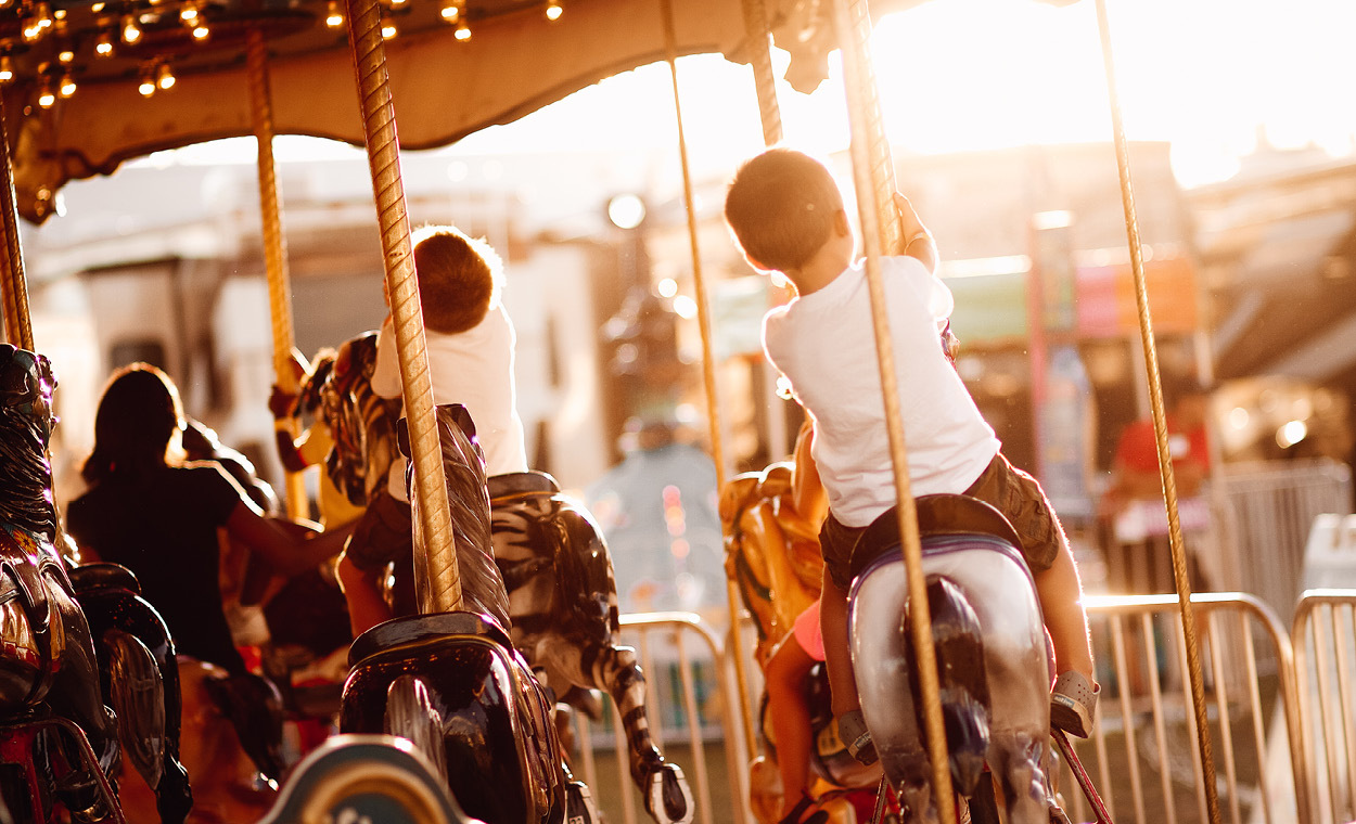 Children riding a carousel.