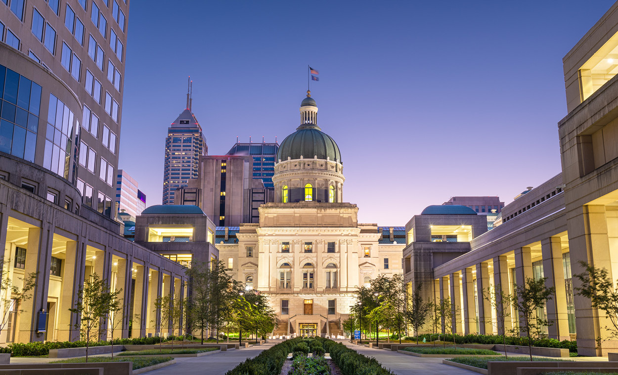 Large building with a dome at the end of a row of other buildings.
