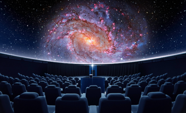 Rows of seats set under a large screen displaying stars in space.
