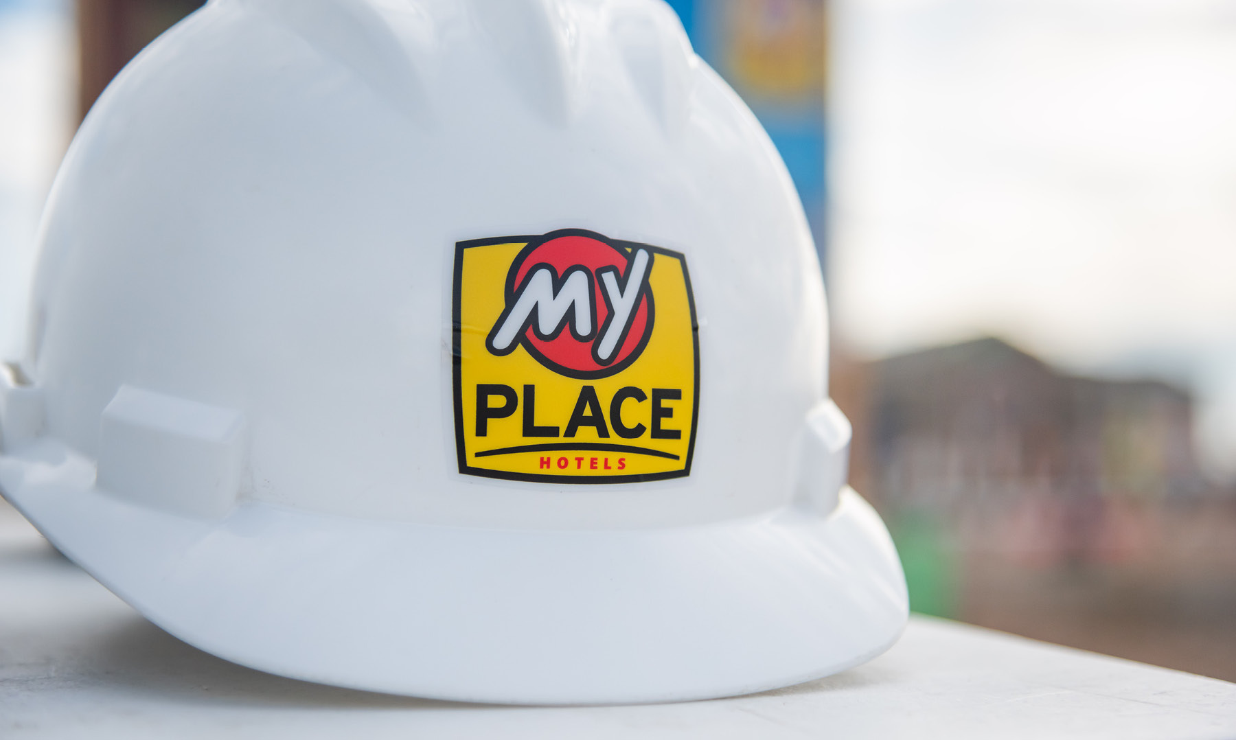 White hard hat with yellow and red My Place Hotel logo front and center.
