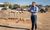 Ryan Rivett standing in front of a pile of dirt with 7 shovels holding white My Place Hotel hard hats.