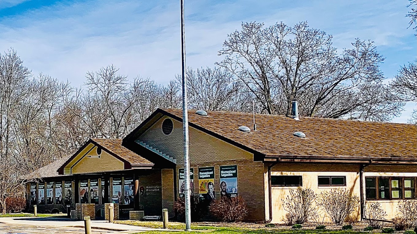 An outside view of a museum house with lots of posters about history posted on the sides of the building.