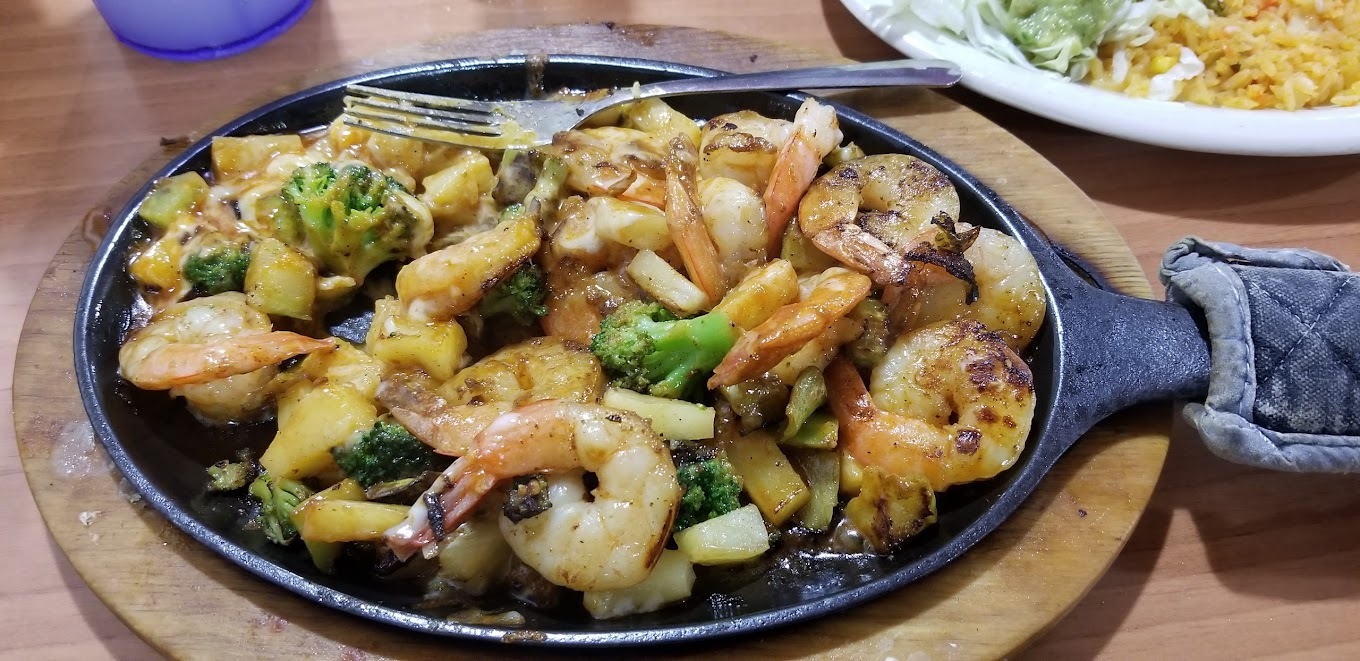 A view of a fajita dish made with shrimp, broccoli, and zucchini.