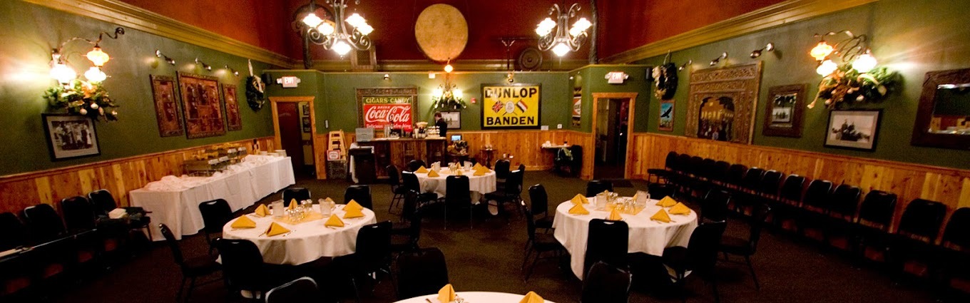 A dark room with moody lighting and many tables, memorabilia lines the walls.