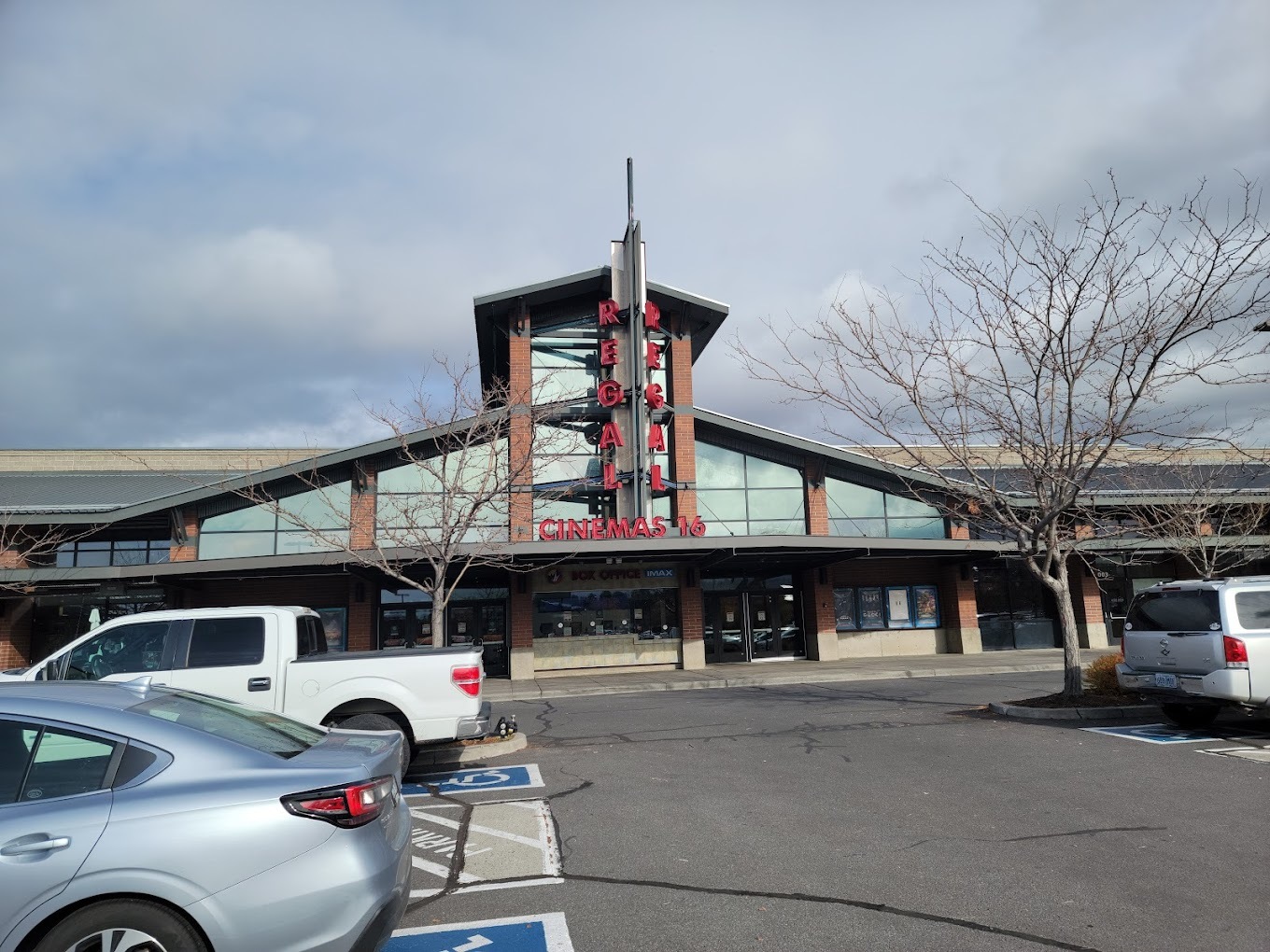 The outside view of a movie theater, featuring large glass windows.