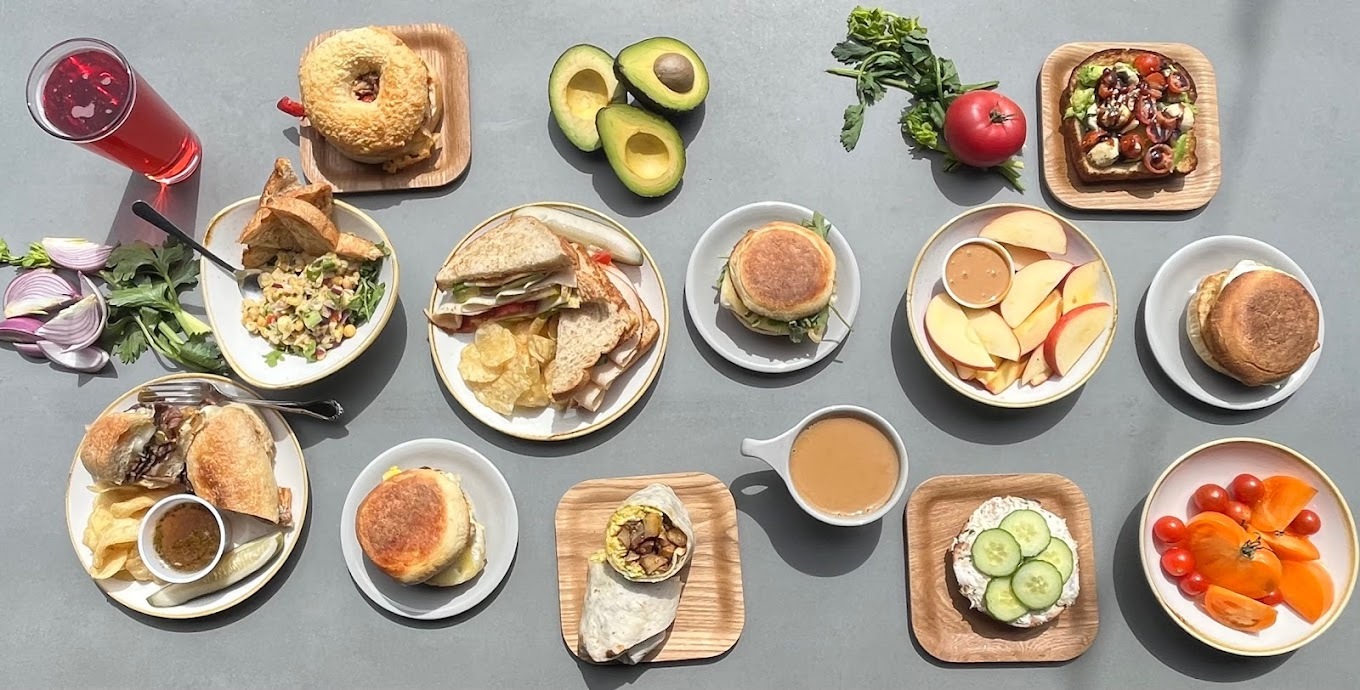 A table spread of many various kinds of pastries, drinks, sandwiches, and dishes.