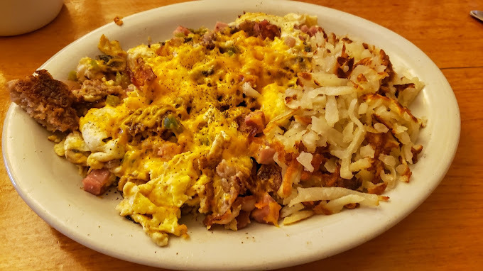 Eggs and hashbrowns on a white plate.