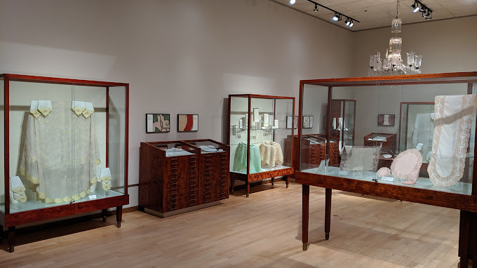 A room full of glass display cases, light up and filled with pieces of art.